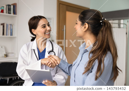Doctor holding digital tablet and shaking hands with patient Doctor holding digital tablet and shaking hands with patient 143793432