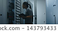 Network Engineer Examining Structured Patch Cables and Reviewing Technical Data on Tablet 143793433