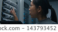 Female Network Engineer Using Tablet and Headset to Coordinate Technical Tasks 143793452