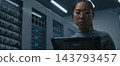 Young Female IT Specialist Reviews Technical Data on Tablet in Modern Server Room. 143793457