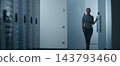 Network Engineer Examining Structured Patch Cables and Reviewing Technical Data on Tablet 143793460