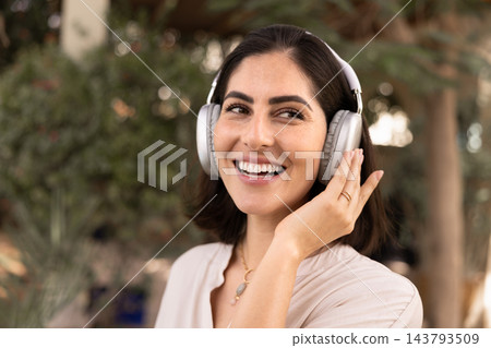 Happy woman listening to music with headphones outdoors 143793509