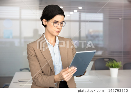 Focused Caucasian businesswoman working on business tasks using digital tablet 143793550