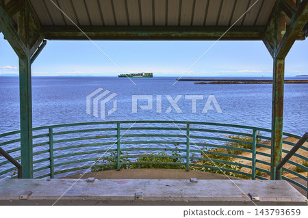 Waterfront Lookout Structure and Container Ship on Blue Bay in Port Angeles Washington 143793659
