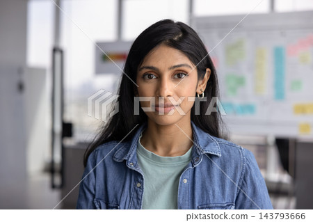 Headshot South Asian female professional looking at camera in office Headshot South Asian female professional looking at camera in office 143793666