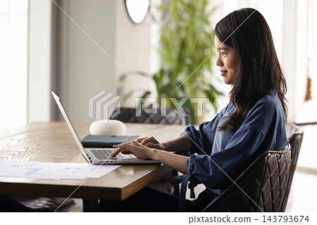 Woman working on laptop in modern home office Woman working on laptop in modern home office 143793674