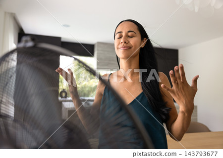 Adult 30s New-Zealander woman cooling herself in warm home Adult 30s New-Zealander woman cooling herself in warm home 143793677