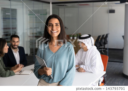 Smiling Latina businesswoman holding digital tablet, looking at camera Smiling Latina businesswoman holding digital tablet, looking at camera 143793701