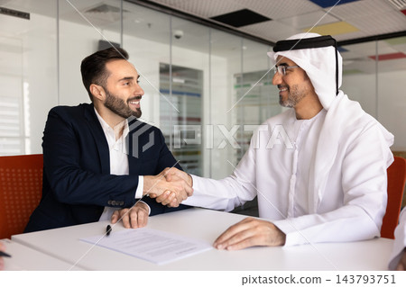 Middle Eastern businessman shaking hands with partner after contract signing 143793751