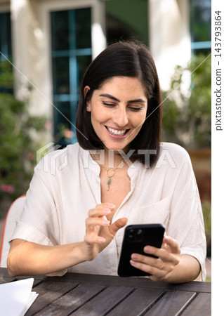 Beautiful woman using smartphone in sunny garden Beautiful woman using smartphone in sunny garden 143793864