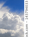 Majestic white cumulus clouds towering against a vivid blue sky. 143794033