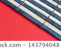 Bamboo Sushi Mat On Red Background With Natural Wood Texture For Food Preparation And Plating 143794048