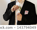 Businessman in a suit hiding a 100 dollar bill and playing cards in his pocket. 143794049