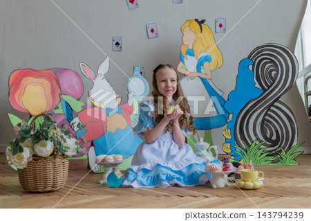 Centered Caucasian Girl Between Large Wonderland Cutouts And Tea Set, Eight Marker Visible, Soft Window Illumination, Pastel Props, Serene Celebrant Posture, DIY Party Backdrop And Cozy Interior Centered Caucasian Girl Between Large Wonderland Cutouts And Tea Set, Eight Marker Visible, Soft Window Illumination, Pastel Props, Serene Celebrant Posture, DIY Party Backdrop And Cozy Interior 143794239