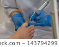 Podiatrist treats patient toenail using professional electric milling cutter in clinic room. Careful specialist holding precision podiatry drill performs hygienic foot care. 143794299