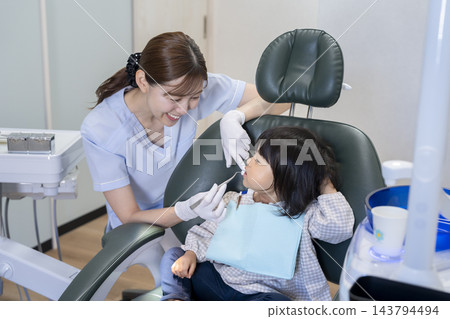 2歲女童正在接受牙齒保健員的氟化物塗抹。 143794494