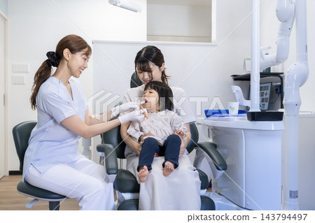一名2歲女童和她的母親在牙科診所接受刷牙指導。 143794497
