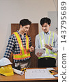 Asian architect and engineer team checking architectural house model using measuring tape on the table at office studio. 143795689