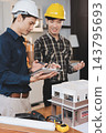 Asian architect and engineer team checking architectural house model using measuring tape on the table at office studio. 143795693