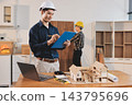 Asian architect and engineer team checking architectural house model using measuring tape on the table at office studio. 143795696