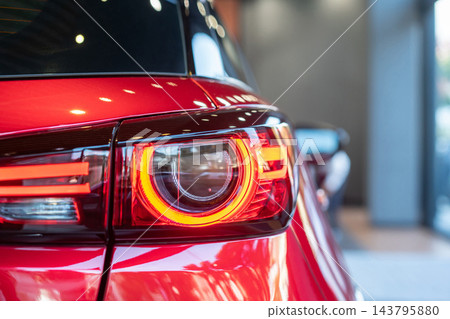 rear view of new modern red car led tail lights in showroom rear view of new modern red car led tail lights in showroom 143795880