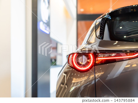 rear view of new modern grey car led tail lights in showroom rear view of new modern grey car led tail lights in showroom 143795884