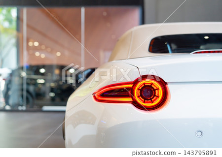 rear view of new modern white sports car led tail lights in showroom 143795891