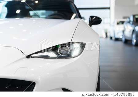 front view of new modern white sports car led headlight in showroom front view of new modern white sports car led headlight in showroom 143795895
