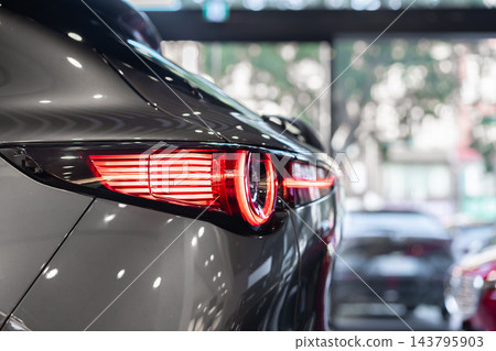 rear view of new modern grey car led tail lights in showroom rear view of new modern grey car led tail lights in showroom 143795903