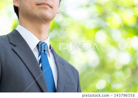 中年商人,穿著清爽的綠色衣服,繫著領帶 中年商人,穿著清爽的綠色衣服,繫著領帶 143796358