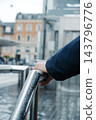 a man rests a hand on a wet railing in Copenhagen 143796776