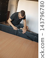 man using a ratchet on a lift-up storage bed 143796780