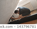 man adjusting the mechanism of a storage bed 143796781