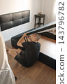 man working beneath a raised storage bed 143796782
