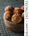 a close-up of pine nut panellets in a wooden bowl 143796783
