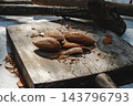 almonds and broken shells beside a rusty hammer 143796793
