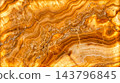 Natural textured golden brown onyx stone surface slab featuring wavy horizontal bands and glowing crystal cracks illuminated completely from behind 143796845