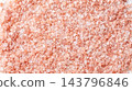 Macro view of pink Himalayan rock salt granules texture full frame scattered raw coarse crystal mineral seasoning food background closeup 143796846