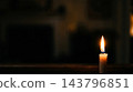 Single burning candle flame illuminating dark room interior for funeral vigil memorial service condolence death loss remembrance mourning and grief prayers 143796851