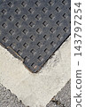 Top view of a cast iron manhole cover in concrete frame 143797254