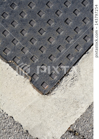 Top view of a cast iron manhole cover in concrete frame Top view of a cast iron manhole cover in concrete frame 143797254
