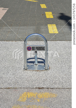 Metal lockable no parking barrier on a concrete pavement 143797258