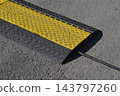 Heavy duty rubber cable protector ramp on an asphalt road 143797260