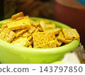 Raw spiced tempeh slices stacked in a green bowl ready for deep frying, Indonesian traditional soybean food 143797850