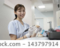 A female dental technician smiling and looking at the camera. 143797914