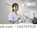 A female dental technician smiling and looking at the camera. 143797916