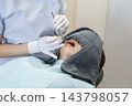 The mouth of a female patient receiving dental treatment. 143798057