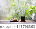 Coffee and Croissant grunge wooden table with philodendron plant pot 143798363