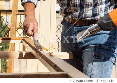 Carpenter at work, restoring an old wooden window. Carpentry. Carpenter at work, restoring an old wooden window. Carpentry. 143798510