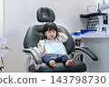 A 2-year-old girl sitting in a dental chair. 143798730
